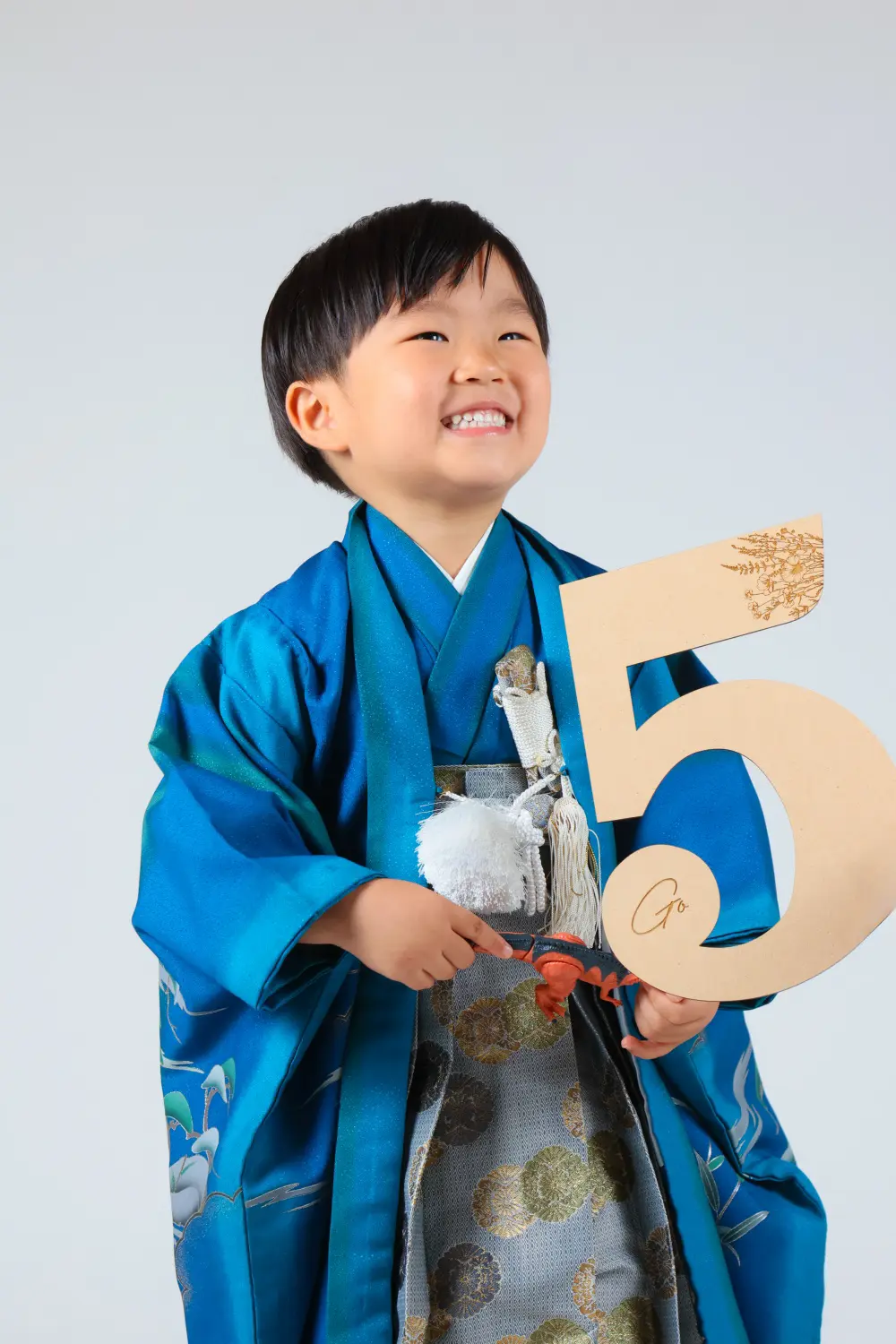 木製の数字5を持って笑う5歳の男の子、青い羽織と袴の七五三スタジオ撮影（金沢店）