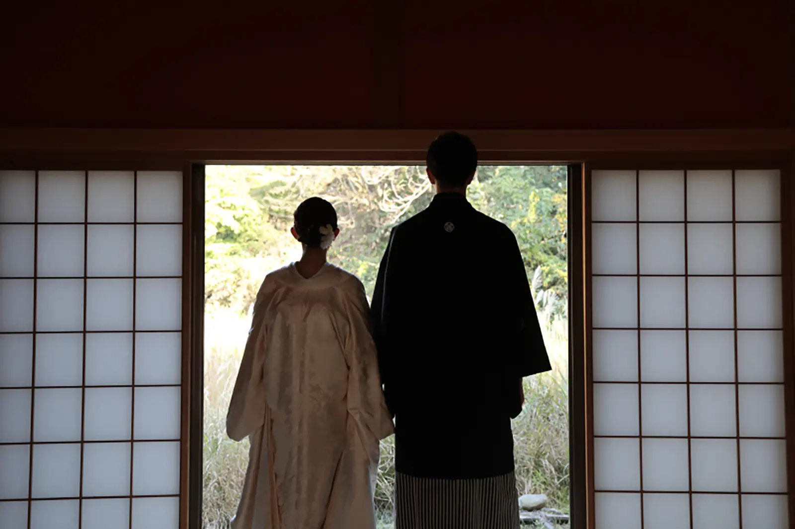 障子越しに並ぶ白無垢と紋付袴のお二人の後ろ姿