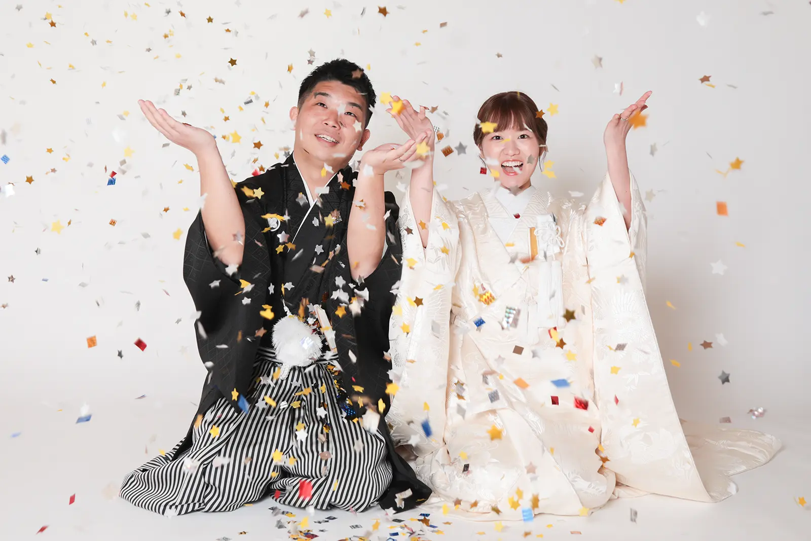 金沢のスタジオで紙吹雪の中に笑顔を見せる和装姿の新郎新婦