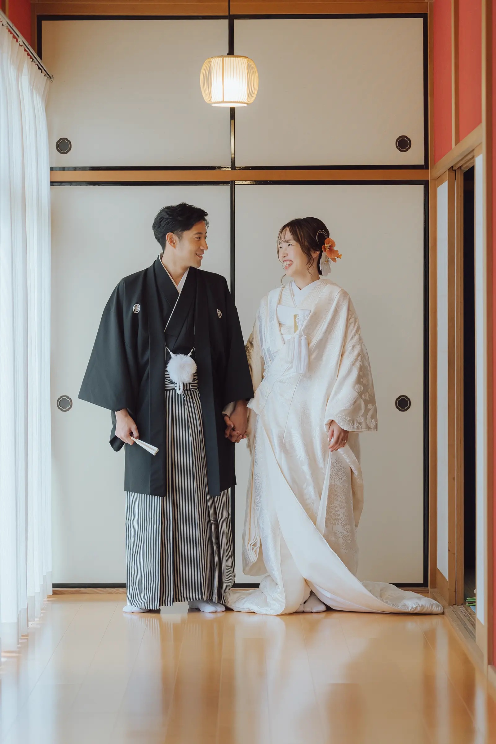 金沢のスタジオで白無垢姿の新婦と紋付袴姿の新郎が手をつないで立つ写真