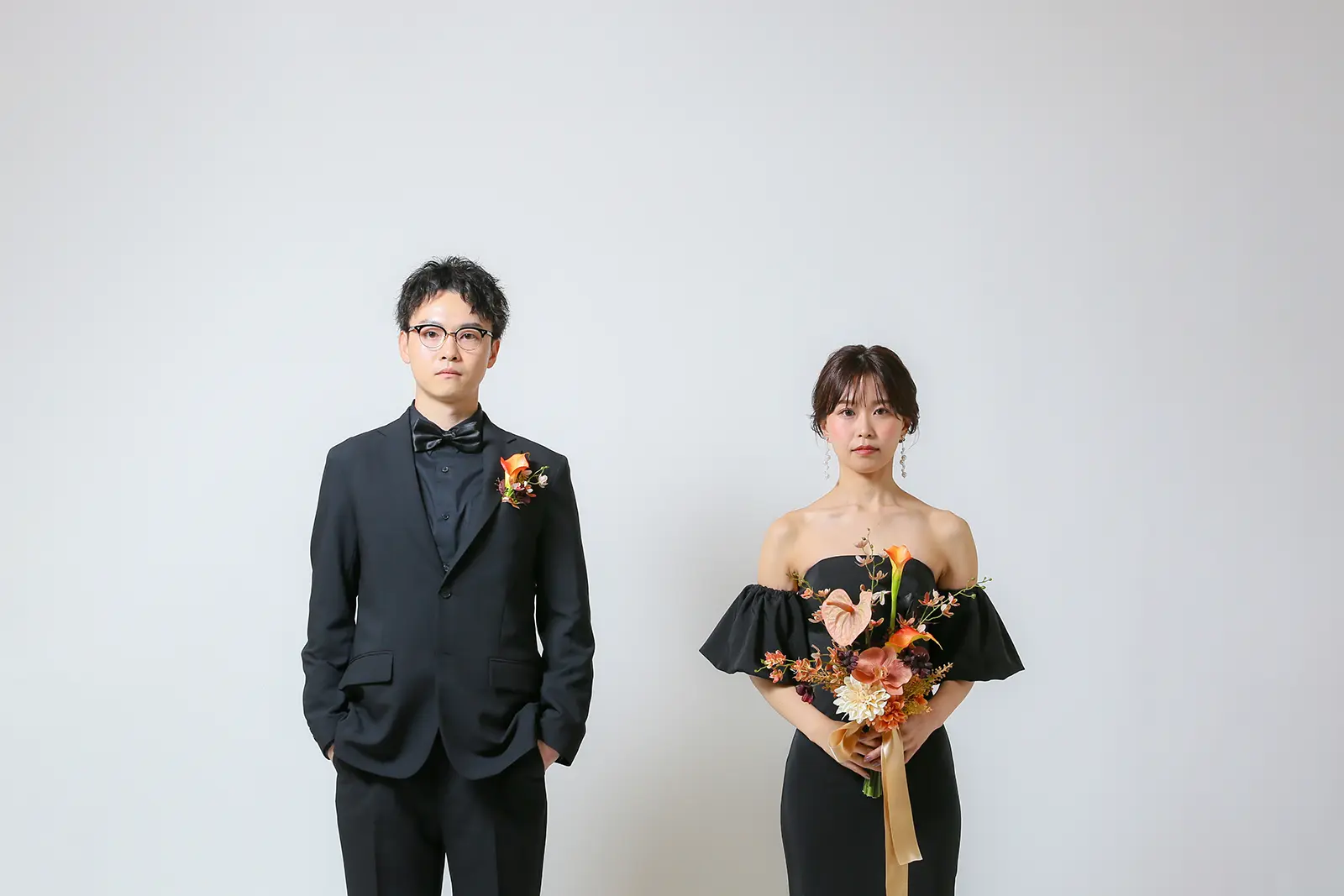 金沢のスタジオでブラックドレスとブラックタキシード姿で立つ新郎新婦