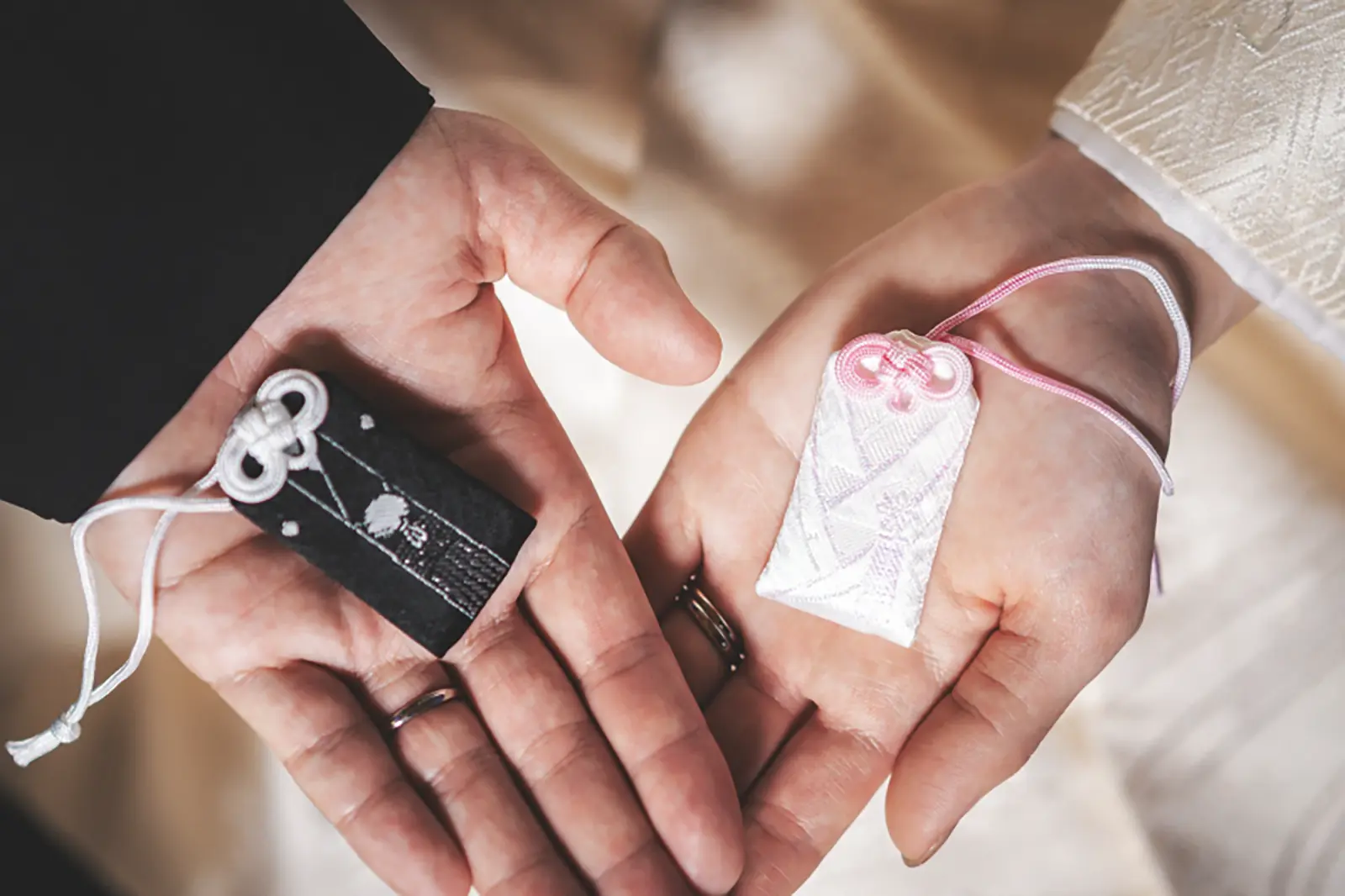 お守りを手に持つ新郎新婦の手元を写したフォトウェディング写真