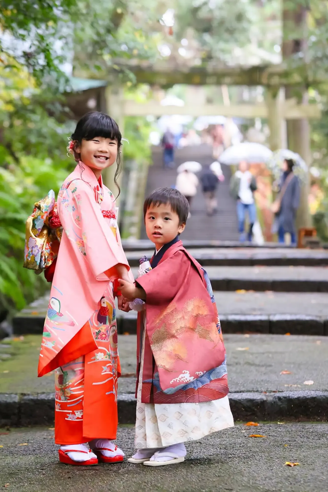神社の石段で手をつなぐ七五三のきょうだい｜ピンクの着物の女の子と羽織袴の男の子｜フォトジェリッシュ金沢店