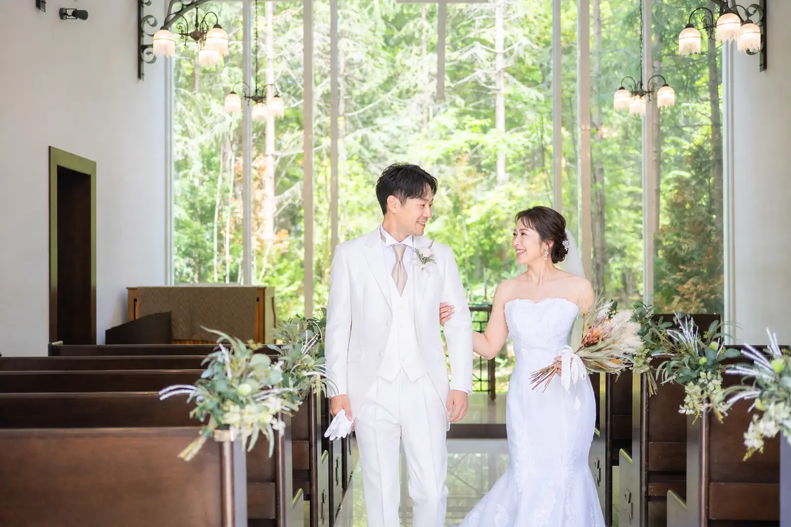軽井沢のチャペルでバージンロードを歩く新郎新婦のフォトウェディング写真
