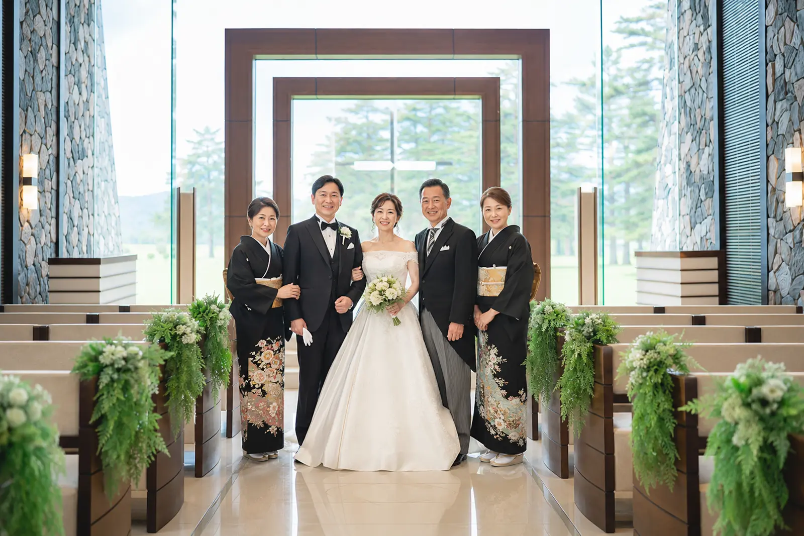 軽井沢のチャペルで新郎新婦と両家の親が並ぶ家族集合写真