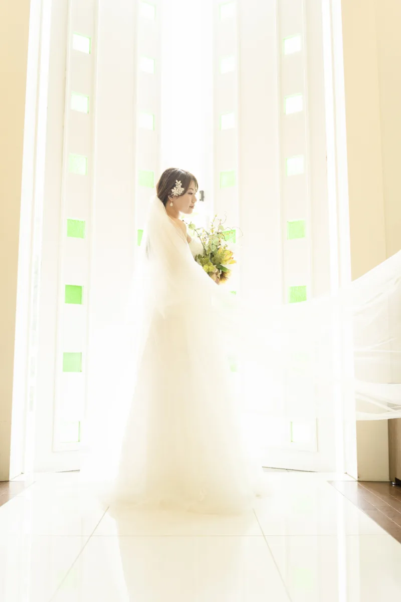 軽井沢のチャペルで、ロングベールをまとい逆光に浮かぶウエディングドレスの花嫁|ナチュラルなフォトウェディング