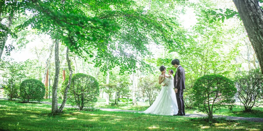 軽井沢の緑に囲まれたガーデンで新郎新婦と子どもが過ごすフォトウェディング