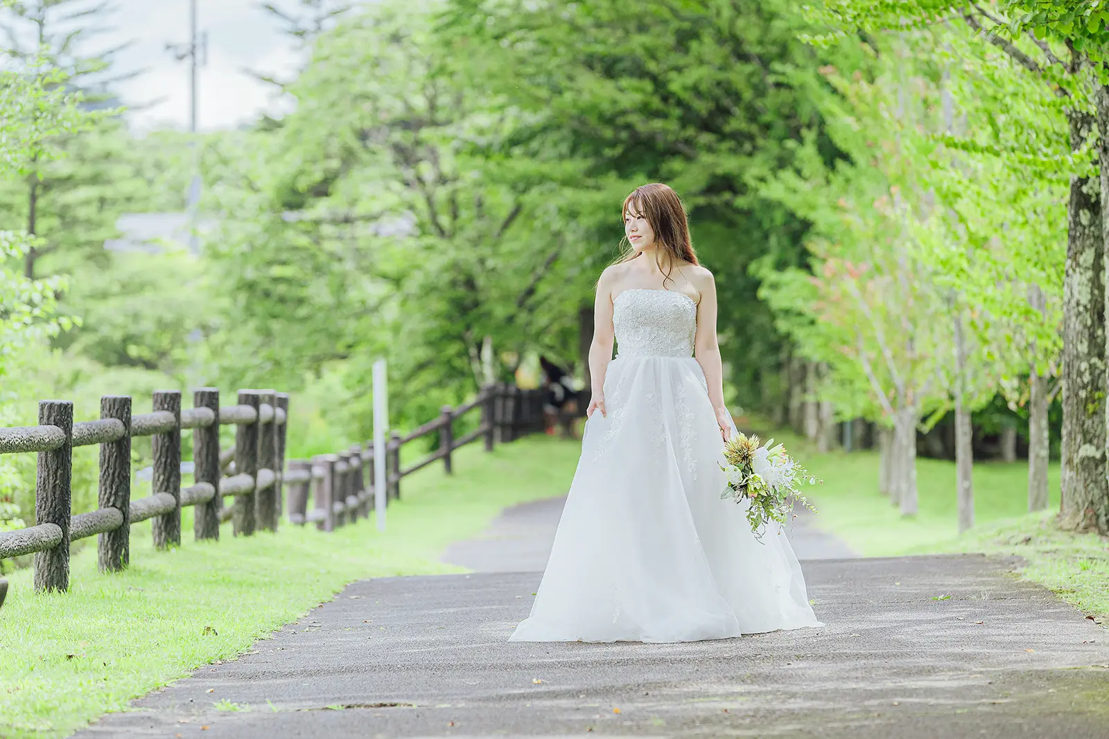 軽井沢の緑豊かな遊歩道で撮影するドレス姿の花嫁