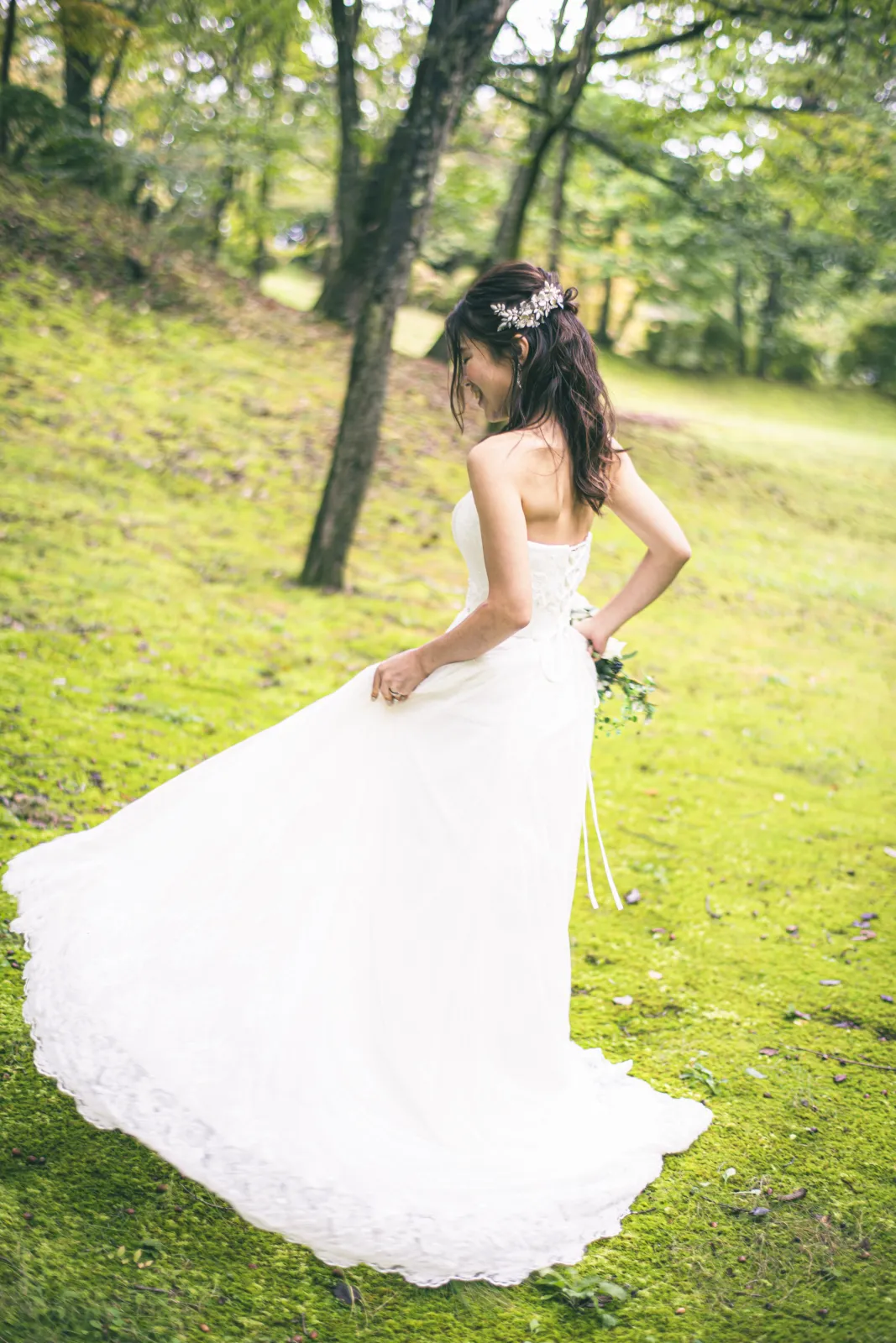 軽井沢の緑豊かな森でウェディングドレスの裾を翻して笑う新婦