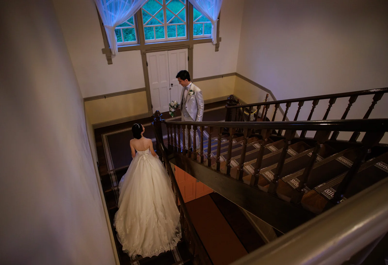 旧三笠ホテルの中央階段を上から見下ろし、階段を上がる新婦を捉えたカット
