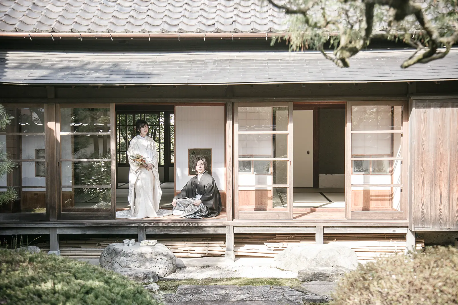 旧高峯家の縁側で白無垢姿の新婦と紋付袴姿の新郎が並ぶ和装フォトウェディング写真