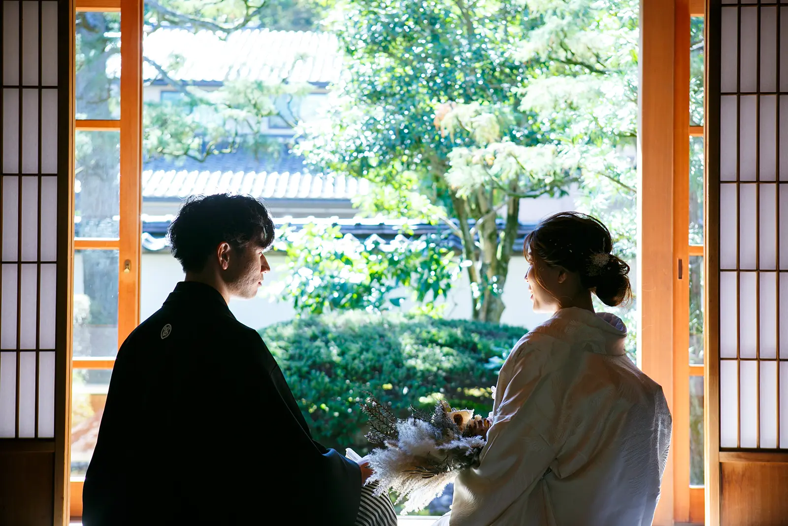 旧高峯家の和室で窓辺の光を受けながら新郎新婦が向かい合う和装フォトウェディング写真