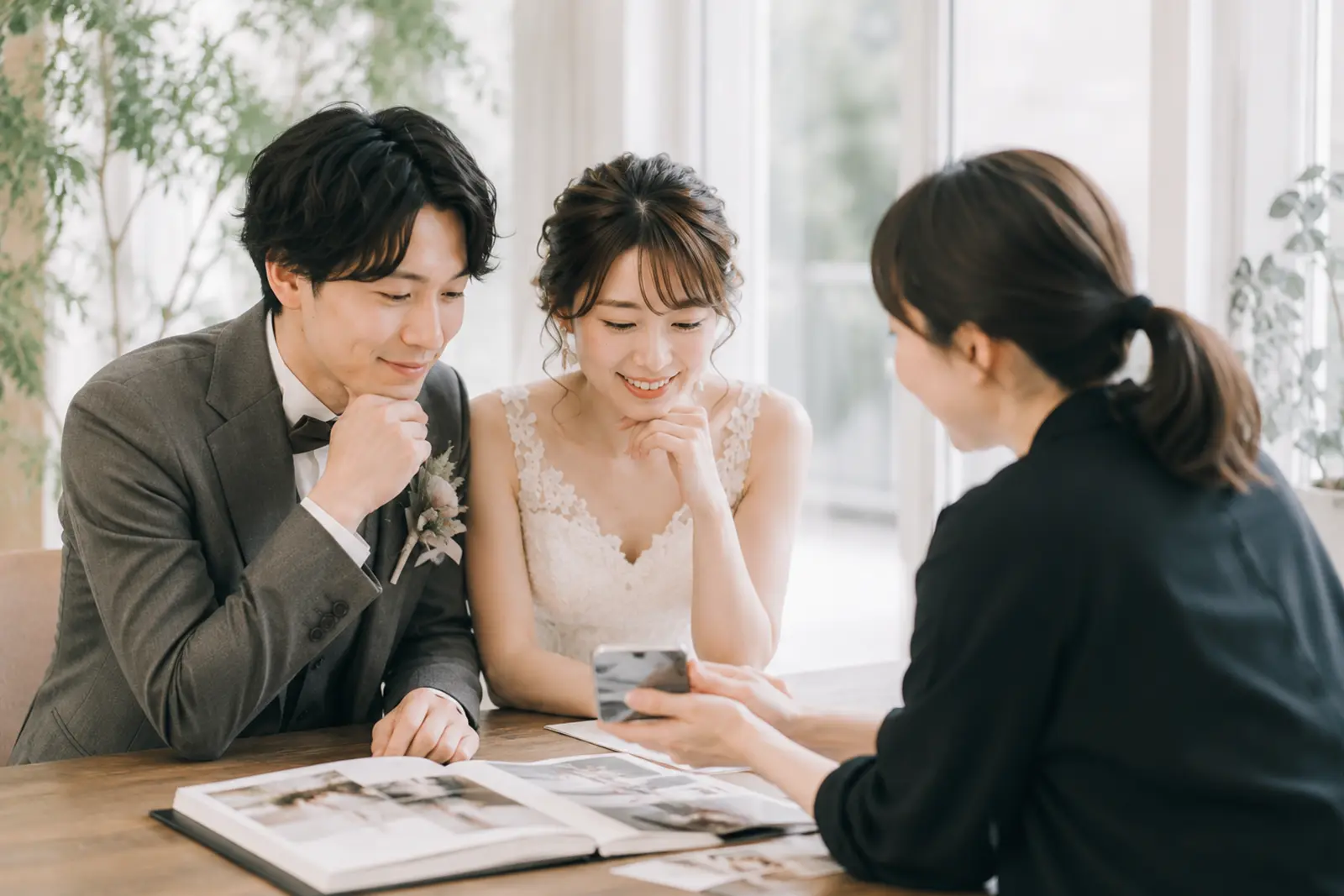 新郎新婦がフォトグラファーと前撮りの撮影要望書や参考写真を相談している様子