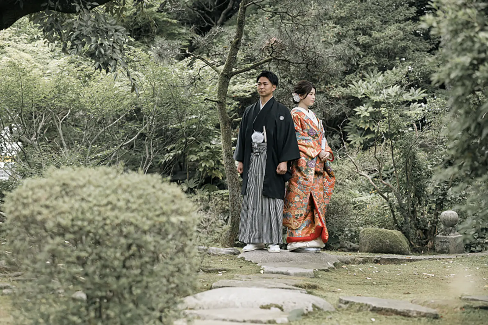 松任ふるさと館の日本庭園で色打掛姿のお二人が並ぶフォトウェディング