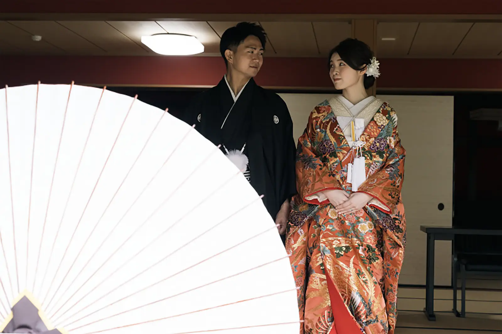 松任ふるさと館で和傘越しに撮影した色打掛姿のお二人