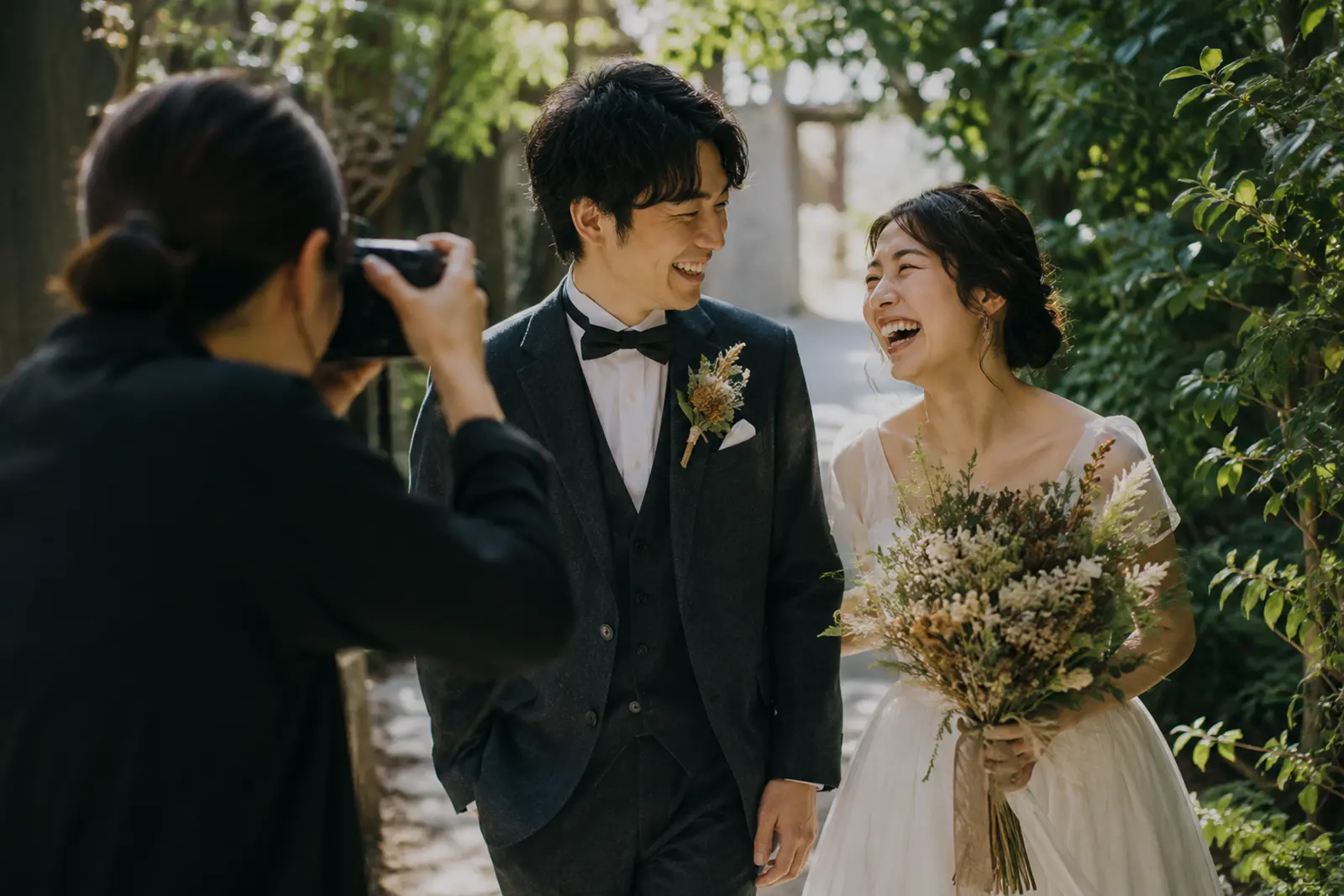 フォトグラファーが自然な笑顔の新郎新婦を撮影しているフォトウェディングシーン
