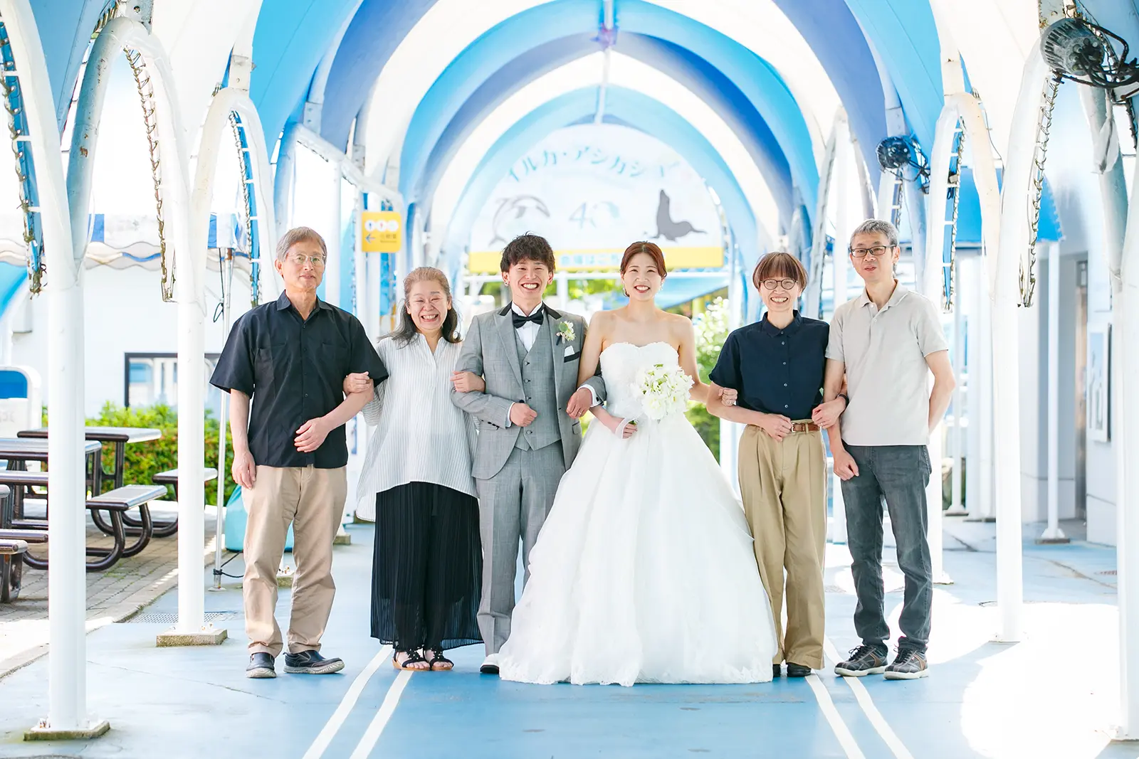 のとじま水族館の通路で新郎新婦と家族が並んで撮影した集合写真
