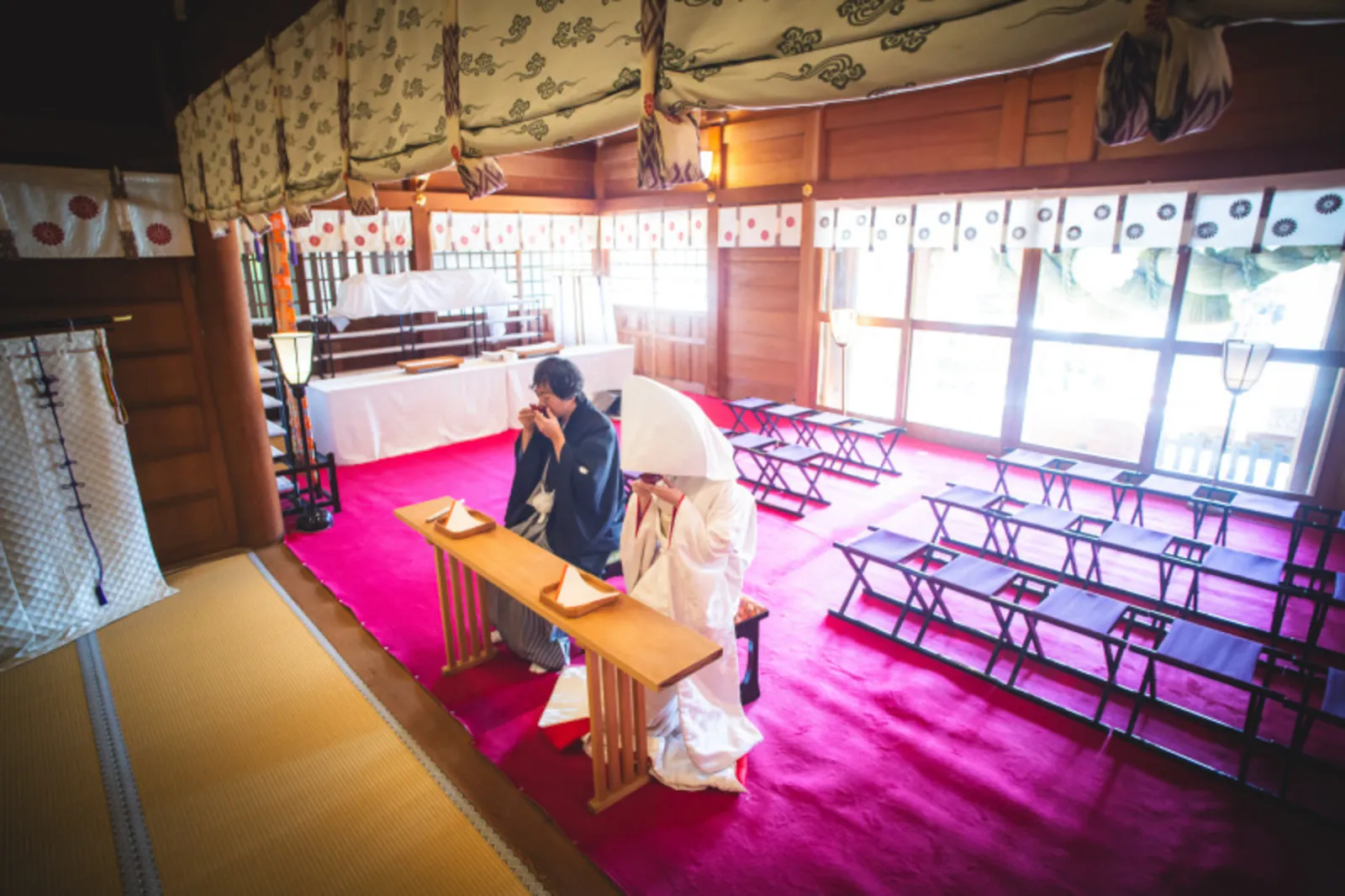 神社で厳かに三々九度（夫婦固めの盃）を交わす和装の新郎新婦