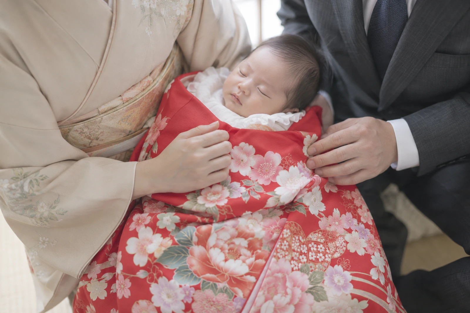 産着の柄に合わせた家族の色合わせ｜赤い祝い着とくすみカラーの装い