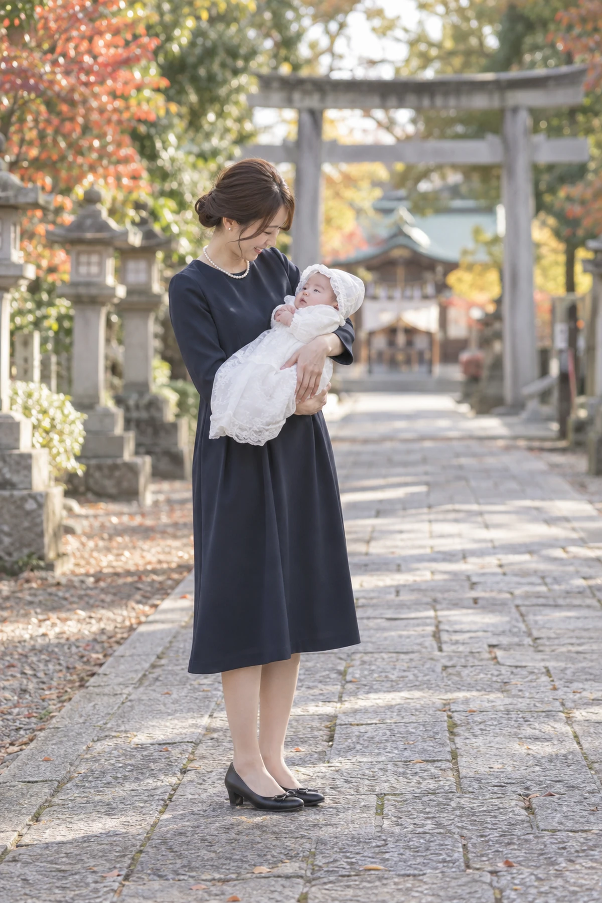 お宮参りの洋装のママ｜ネイビーのセレモニーワンピースで赤ちゃんを抱く