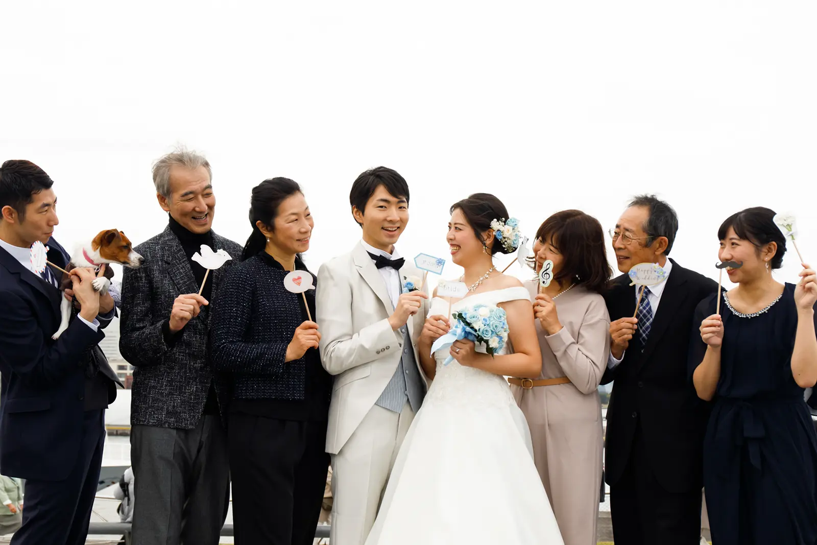 家族と一緒に笑顔で並ぶ新郎新婦のフォトウェディング集合写真