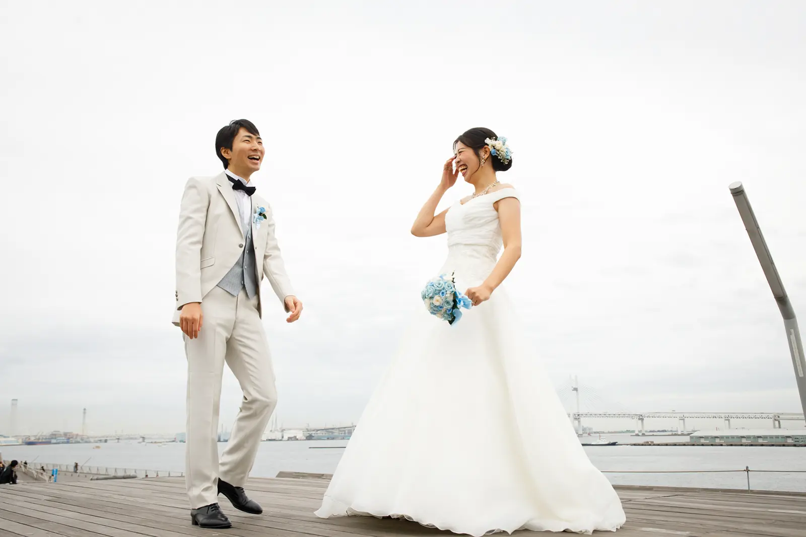 開放的なロケーションで笑い合う新郎新婦のフォトウェディング写真