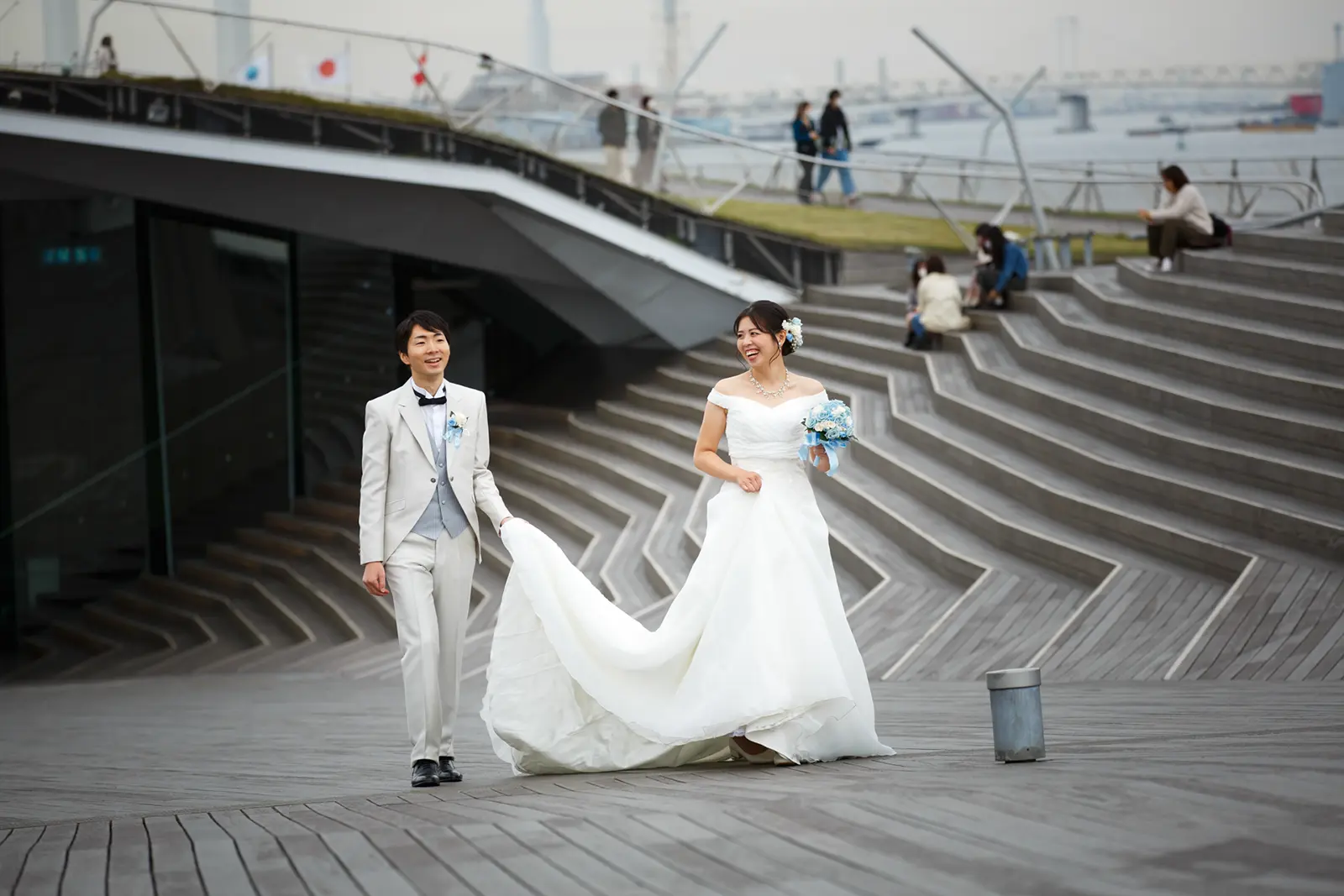 大さん橋を歩きながら笑顔を見せる新郎新婦のフォトウェディング写真