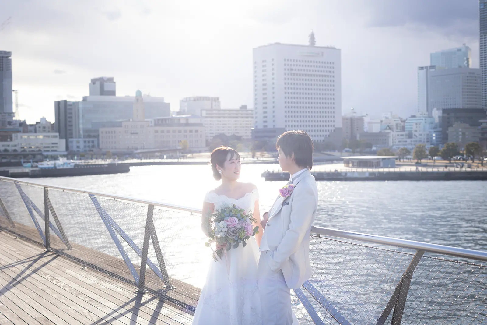 横浜の大さん橋で逆光の中向かい合う新郎新婦