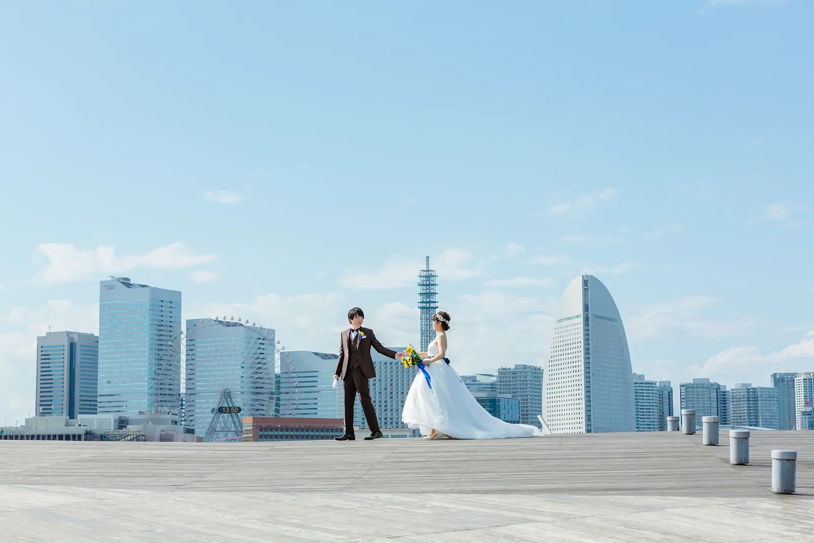 横浜の大さん橋でみなとみらいを背景に立つ新郎新婦