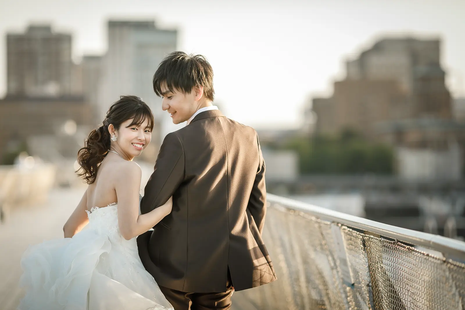 横浜の大さん橋で振り返って笑う新婦と新郎