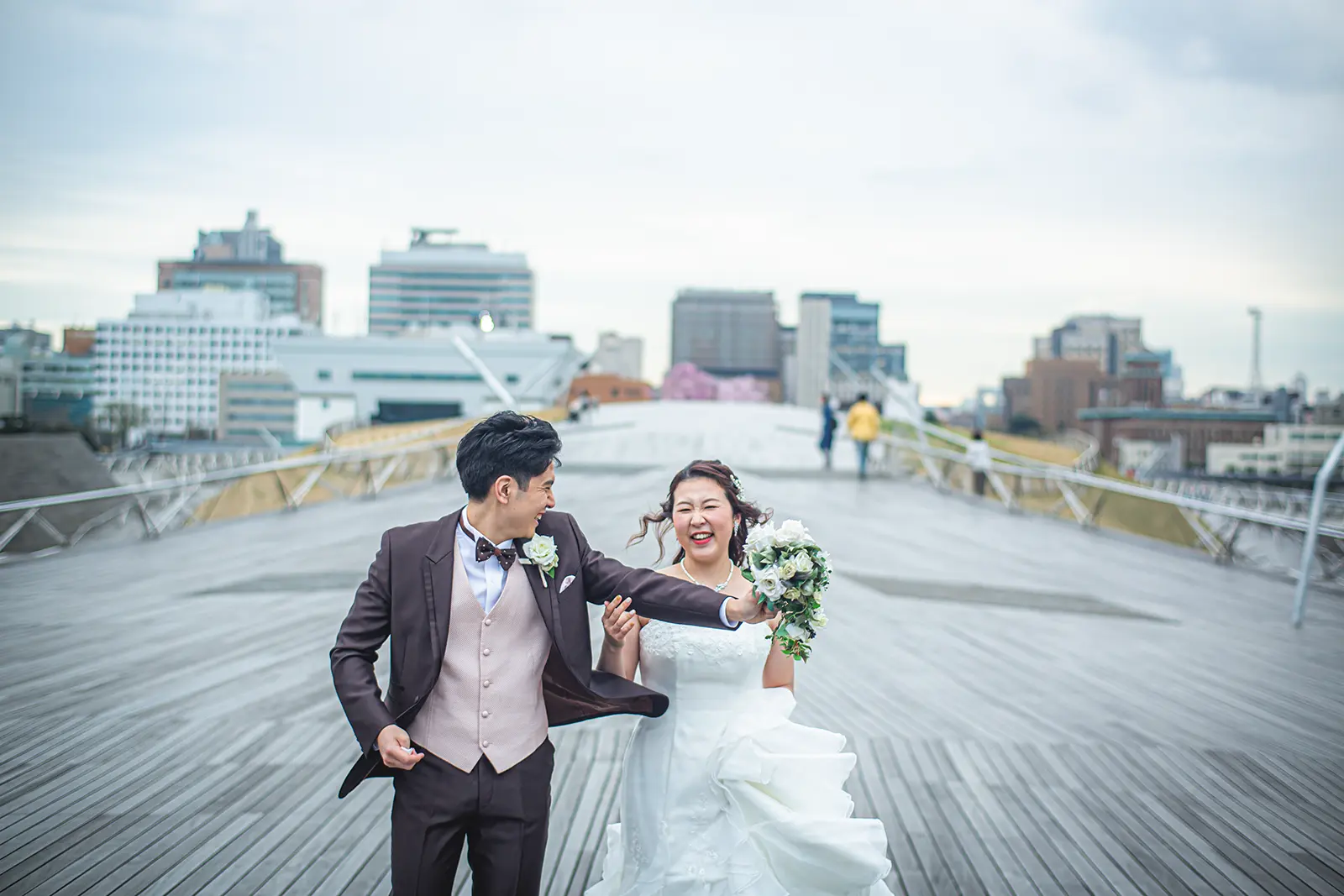 横浜の大さん橋を笑顔で走る新郎新婦