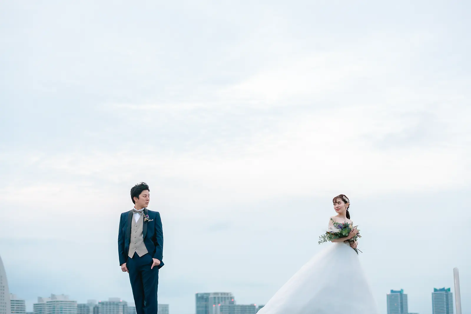 横浜の大さん橋で空を大きく背景に立つ新郎新婦
