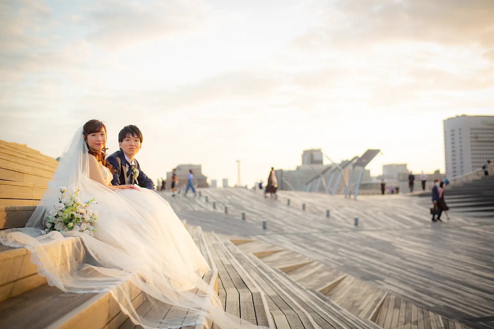 横浜の大さん橋の階段に座る新郎新婦