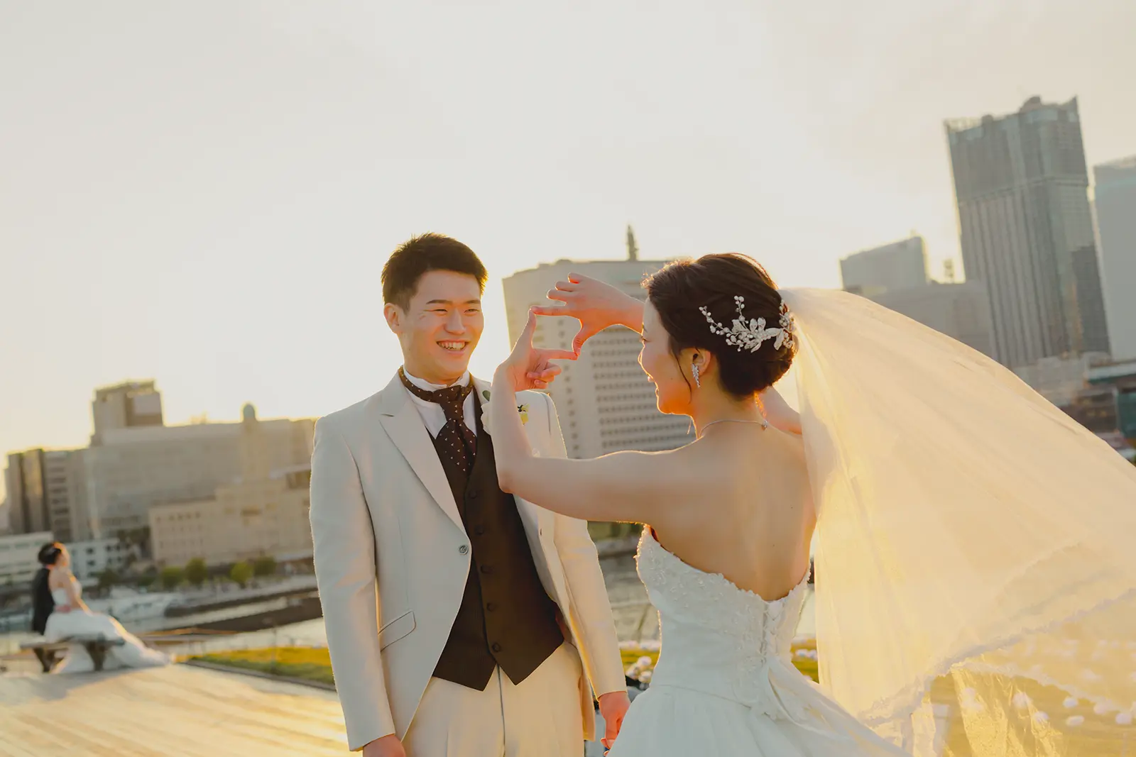 横浜の大さん橋で夕日を背景に笑い合う新郎新婦