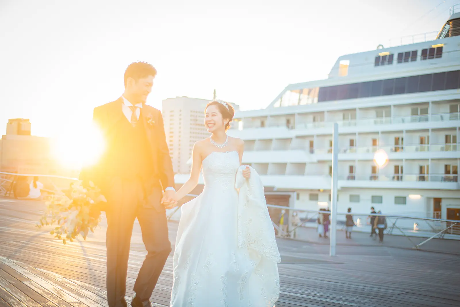 横浜の大さん橋で夕日を浴びながら歩く新郎新婦