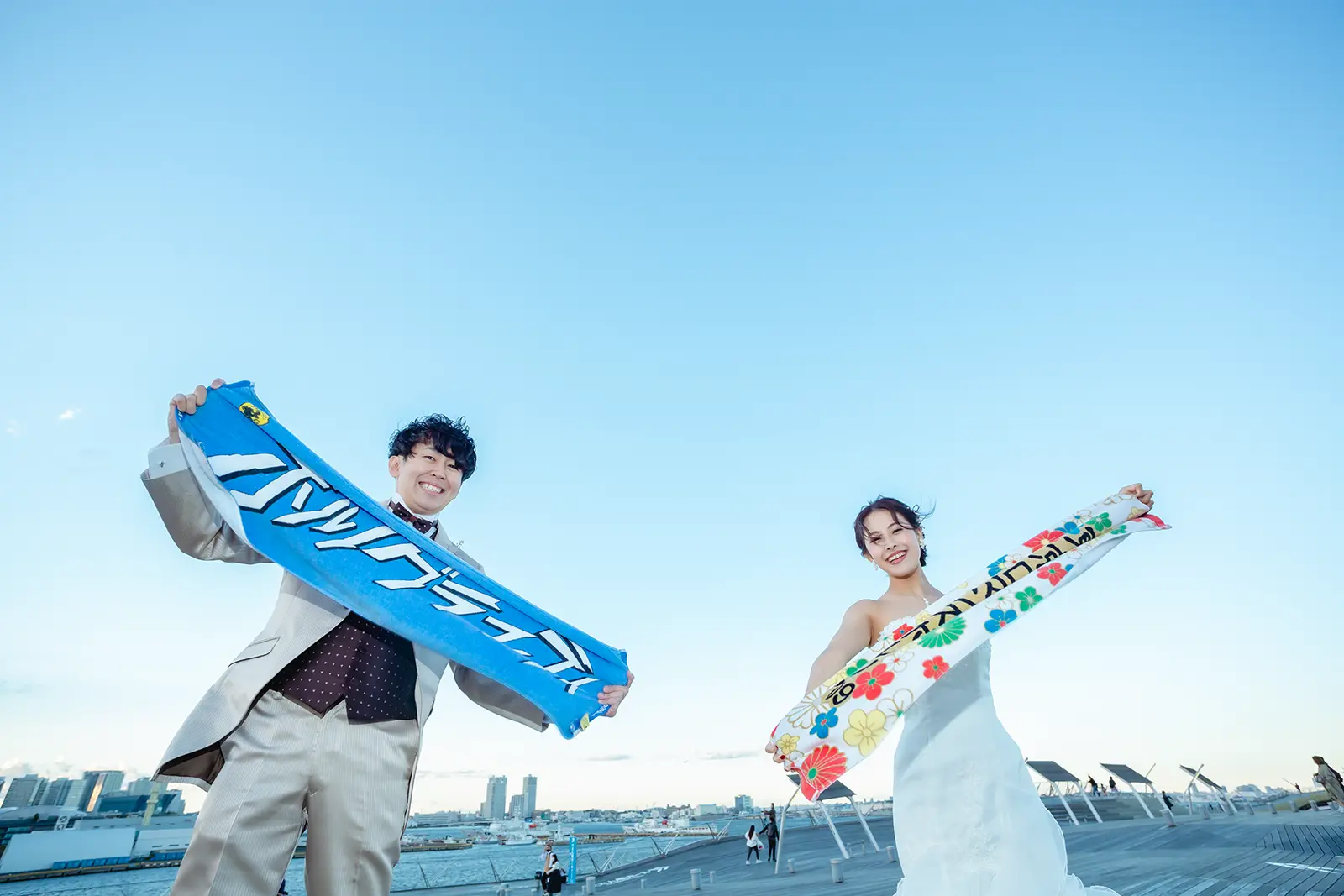 横浜の大さん橋でタオルを持って笑顔を見せる新郎新婦