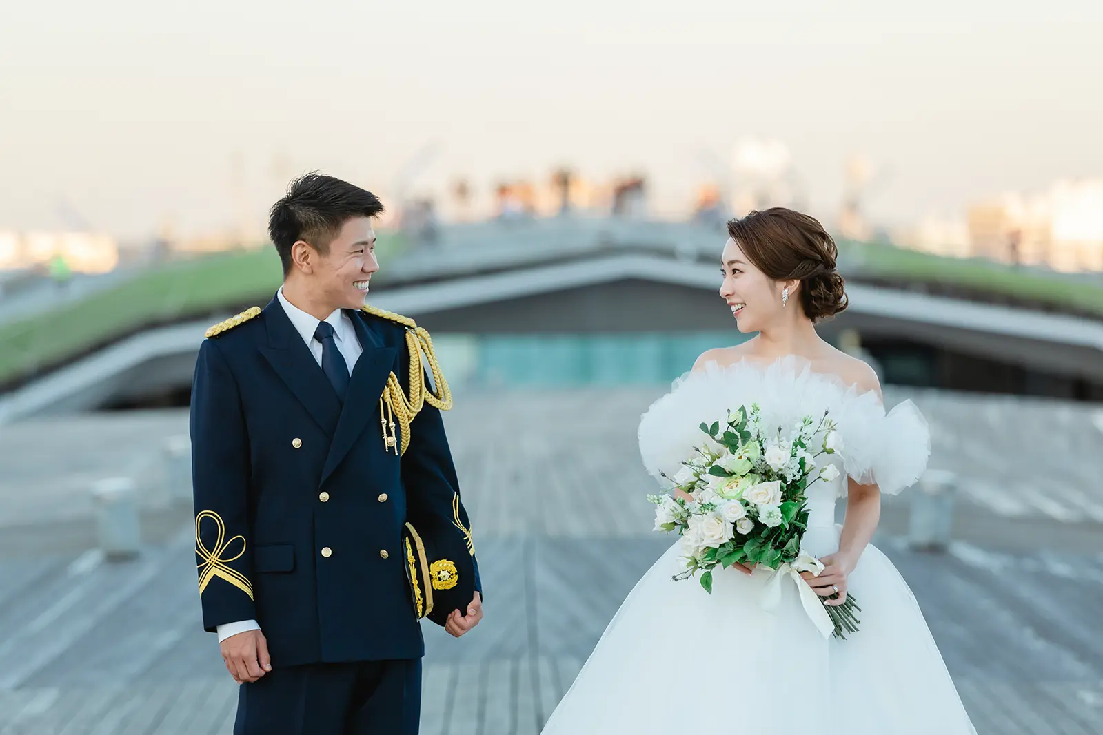横浜の大さん橋で消防士の礼服姿の新郎とドレス姿の新婦が見つめ合う様子