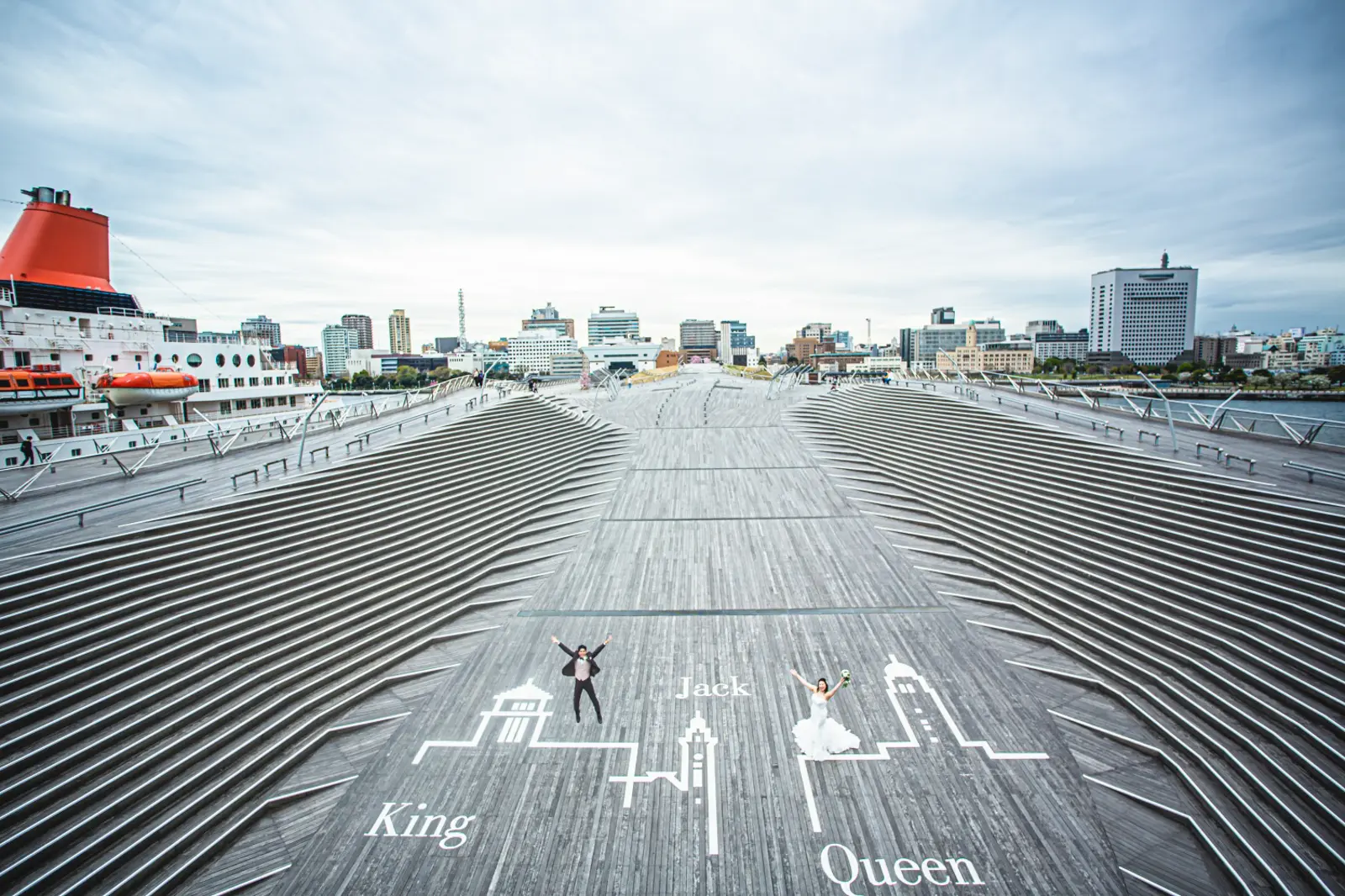 大さん橋のKing&Queenスポットでベールをなびかせる洋装の新郎新婦