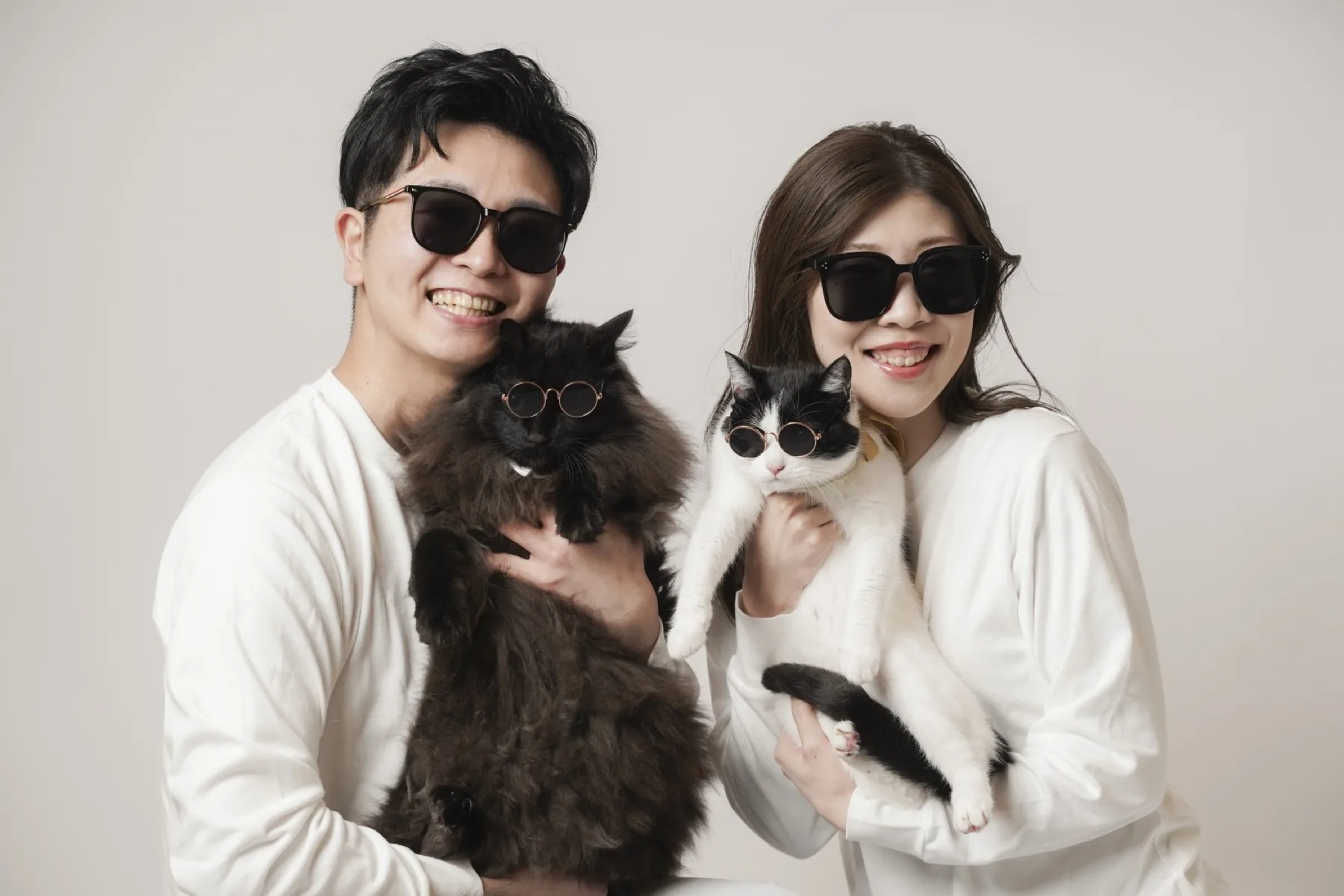 サングラスをかけた2匹の愛猫を抱く新郎新婦、金沢のペットと一緒のフォトウェディング