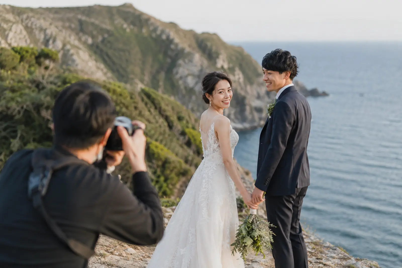 海辺のロケーションで結婚式ムービー用の前撮り撮影をしている新郎新婦