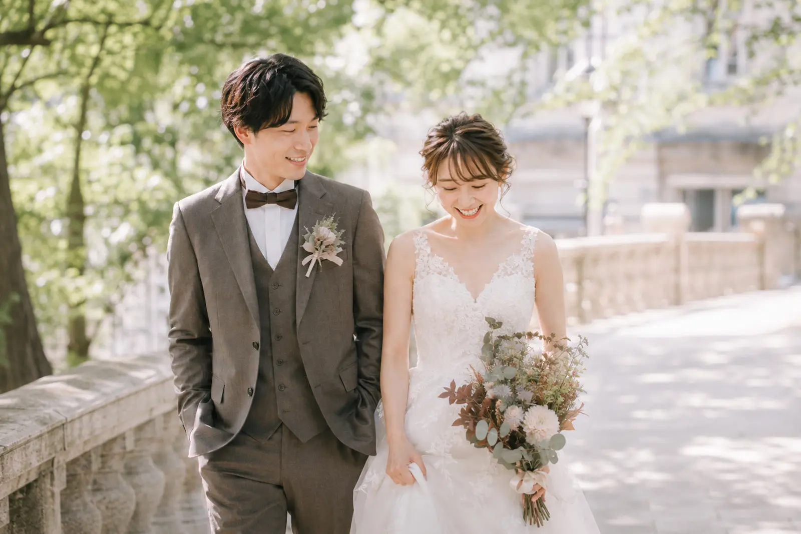 前撮りで新郎新婦が自然に歩きながら笑っているフォトウェディング写真