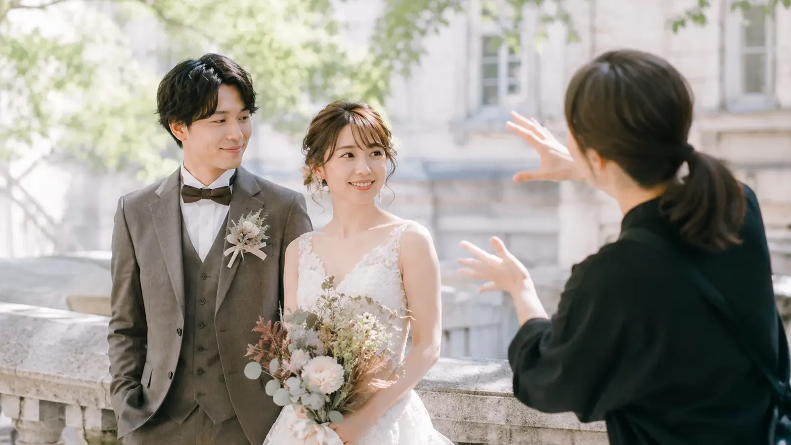 前撮りでフォトグラファーが新郎新婦にポーズを案内しているフォトウェディング撮影風景