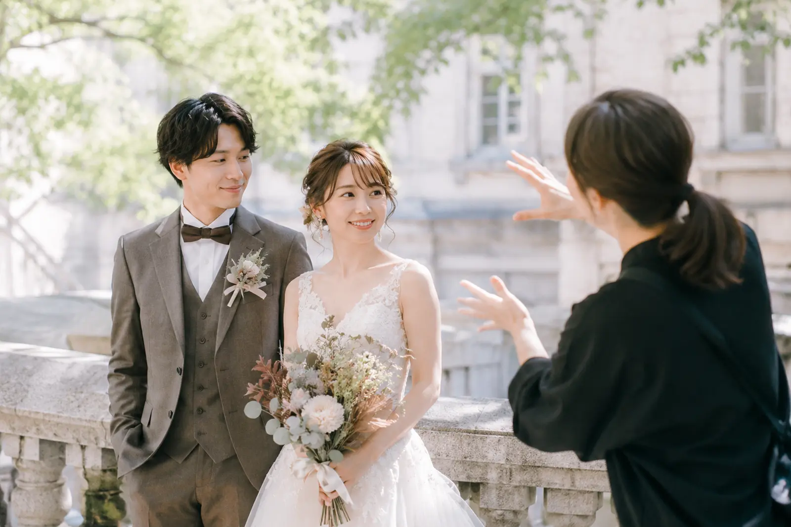 前撮りでフォトグラファーが新郎新婦にポーズを案内しているフォトウェディング撮影風景