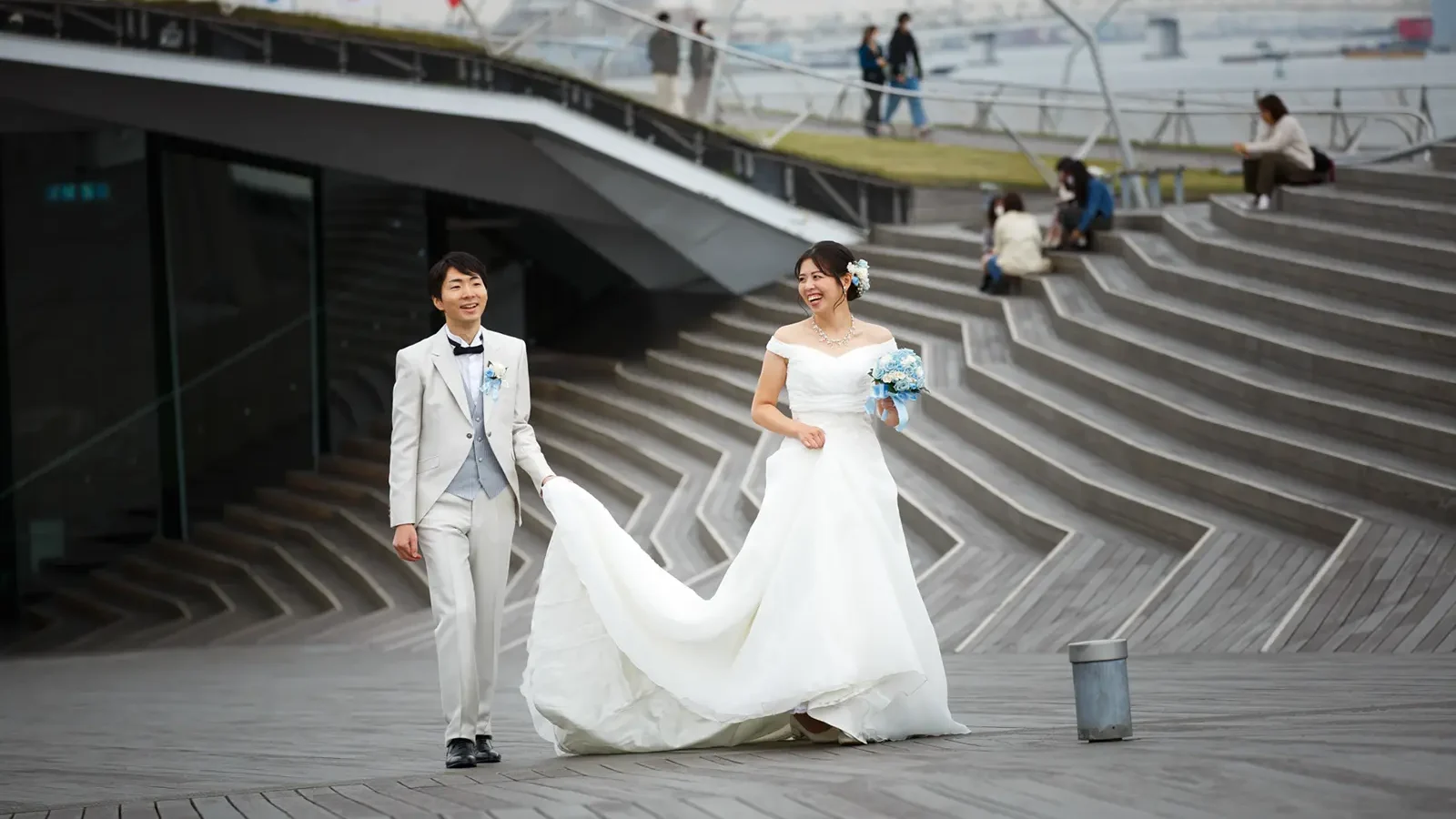 大さん橋で歩きながら笑い合う新郎新婦のフォトウェディング写真