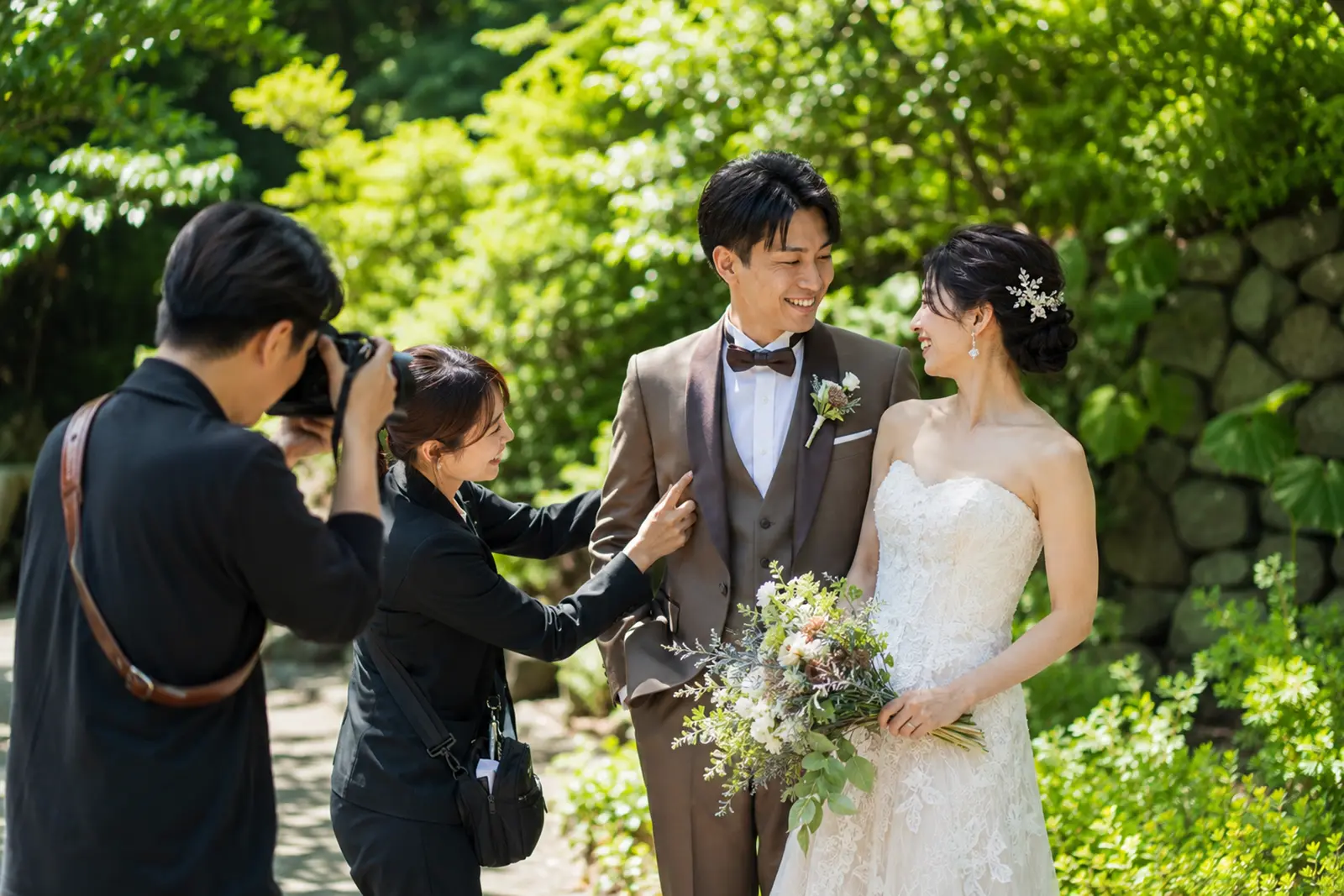 フォトウェディング撮影中にスタッフが新郎新婦をサポートする様子
