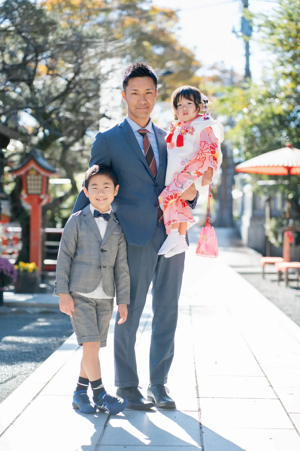 参道で父に抱かれた被布姿の3歳の女の子とグレンチェックの兄、六所神社の七五三（大磯）