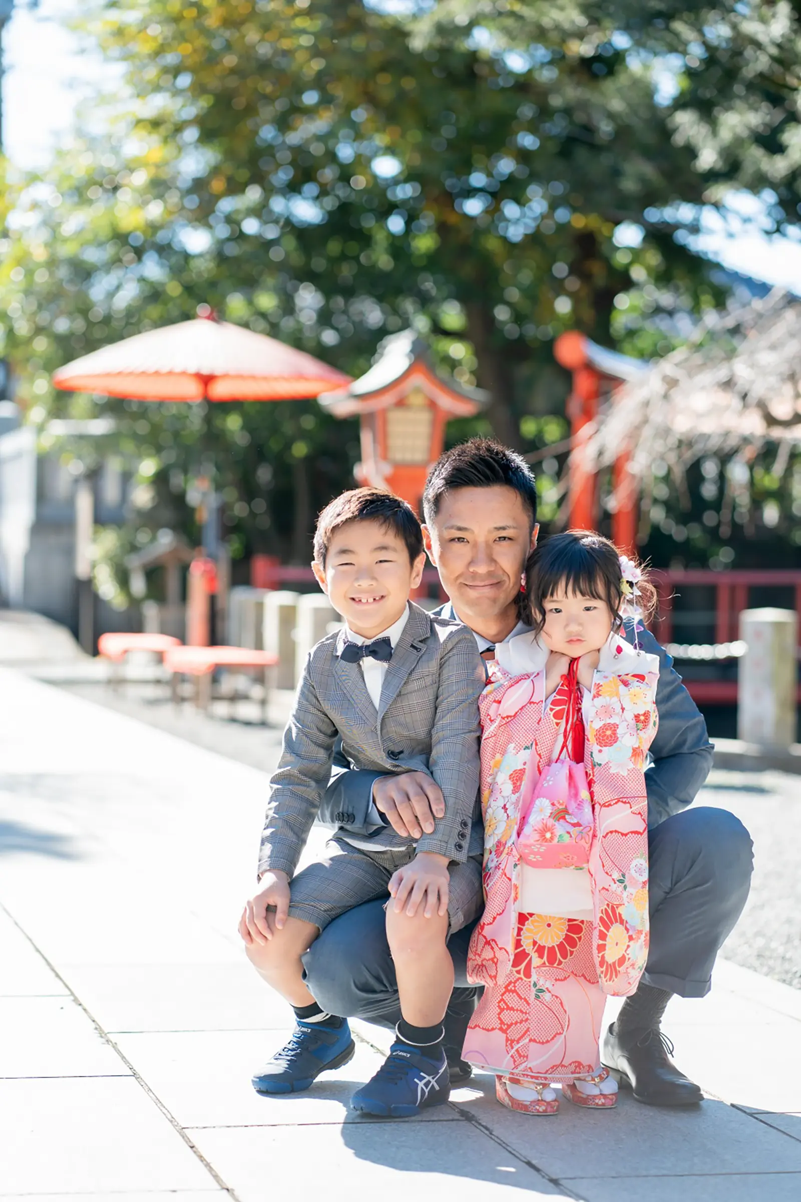 参道で父と並んでしゃがむ被布姿の3歳の女の子と兄、六所神社の七五三撮影（大磯）