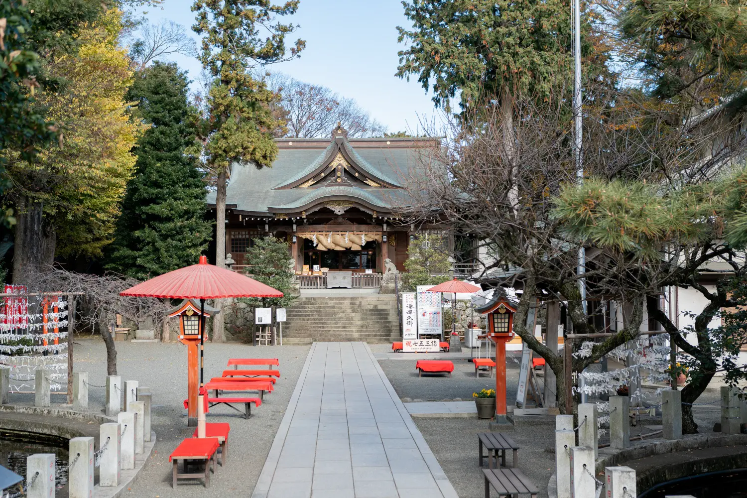 六所神社の参道正面から見た社殿と赤い野点傘・赤い床几、祝七五三詣の看板（神奈川県大磯町の七五三撮影）