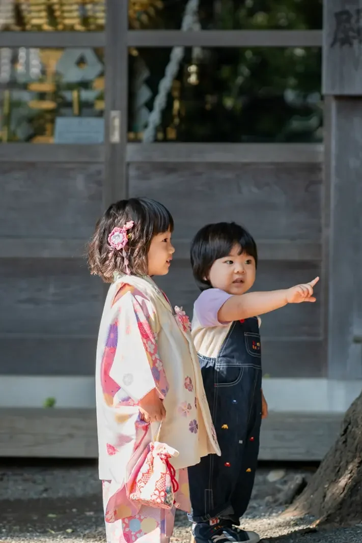 六所神社の境内で弟と並び、大きな木を指さす男の子と被布姿の3歳の女の子の七五三撮影