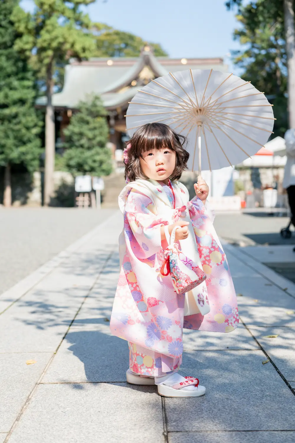 六所神社の参道で白い和傘を差し、被布姿で立つ3歳の女の子の七五三出張撮影（神奈川県大磯町）